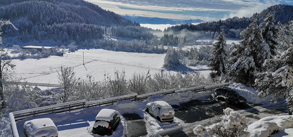 a view of a snow covered mountain with cars parked in the snow