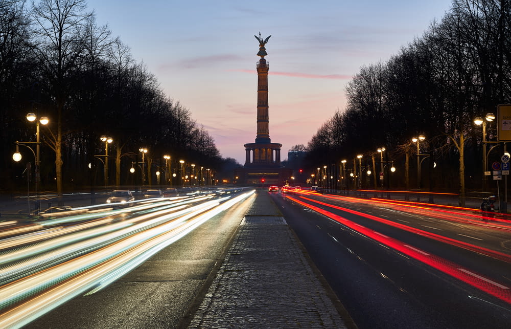a long exposure shot of a street with a monument in the background