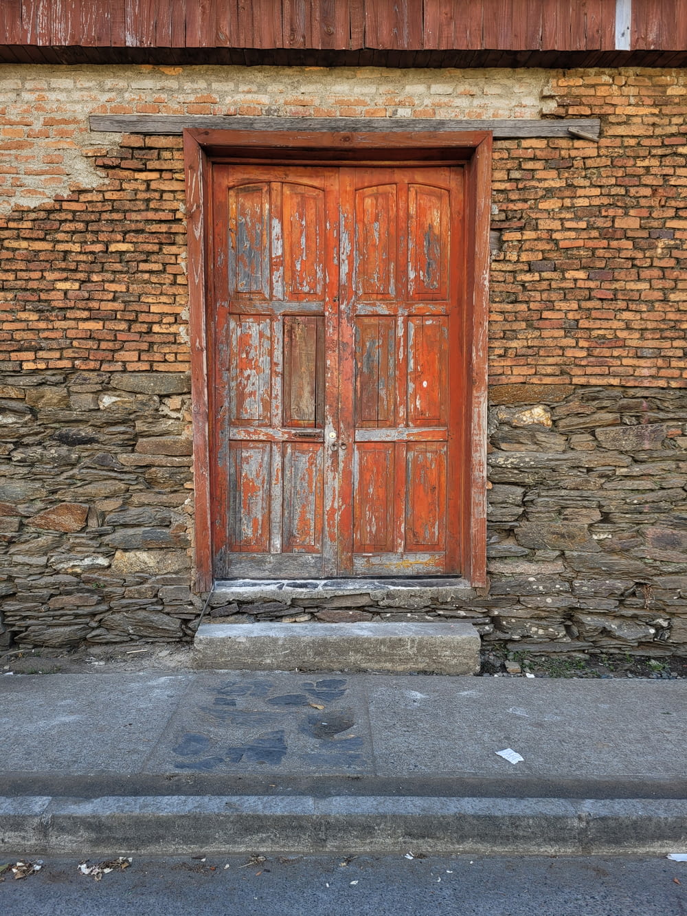 an old wooden door on the side of a brick building