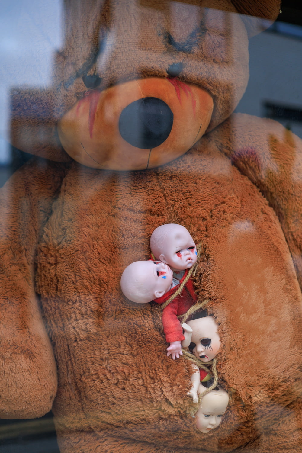a large teddy bear with two dolls in it
