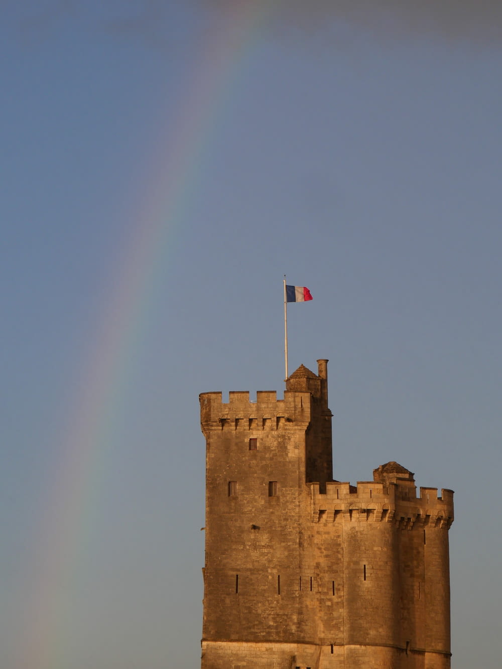 a rainbow in the sky over a castle