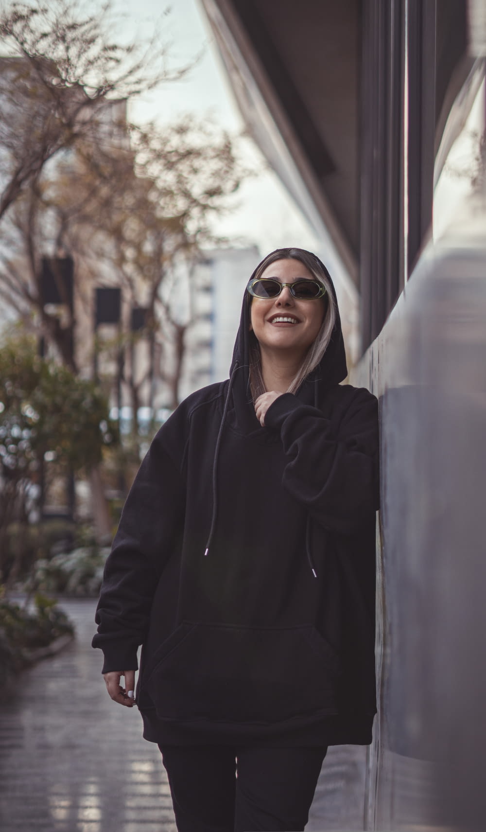 a woman in a black hoodie is walking down the street