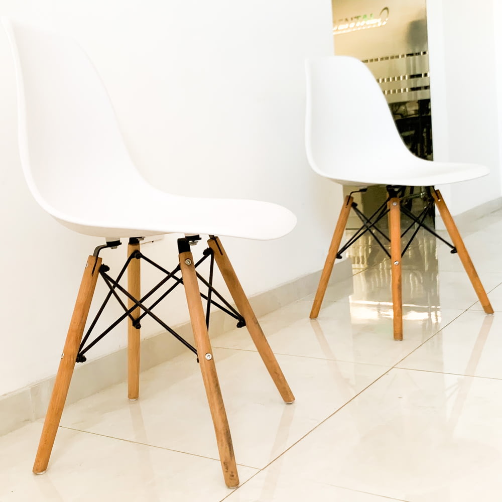 a pair of white chairs sitting next to each other