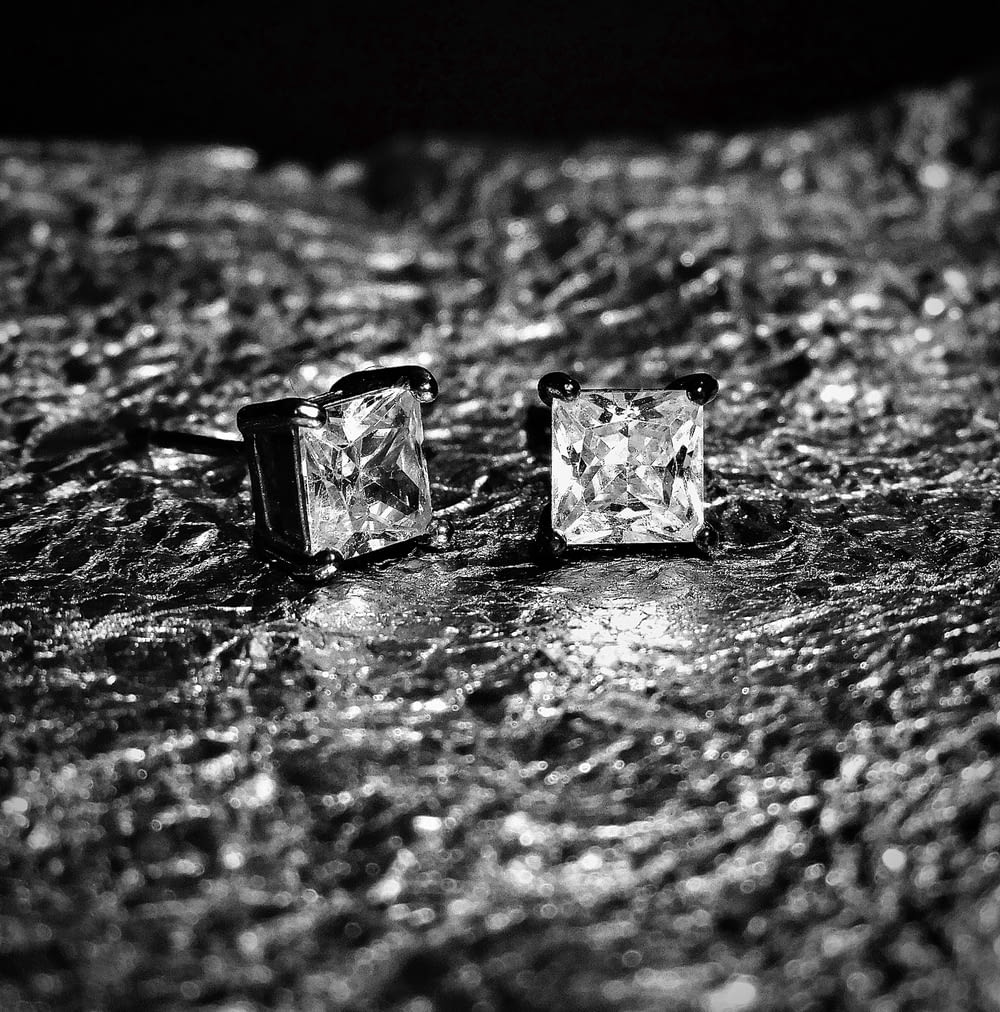 black and white photograph of two square diamond earrings