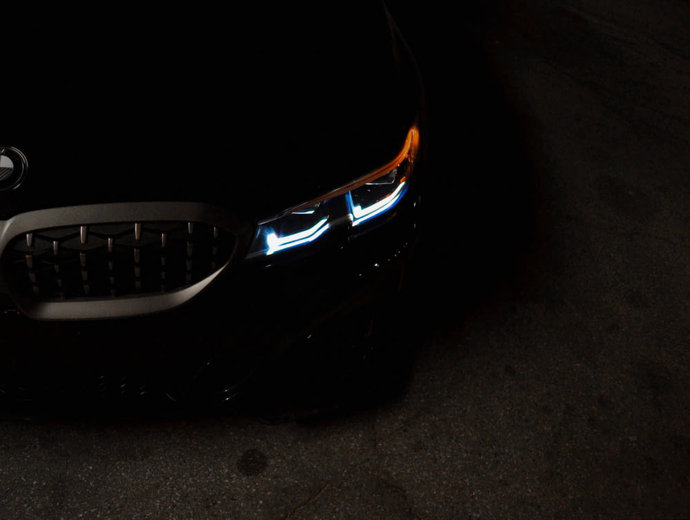 a close up of a car's headlights in the dark