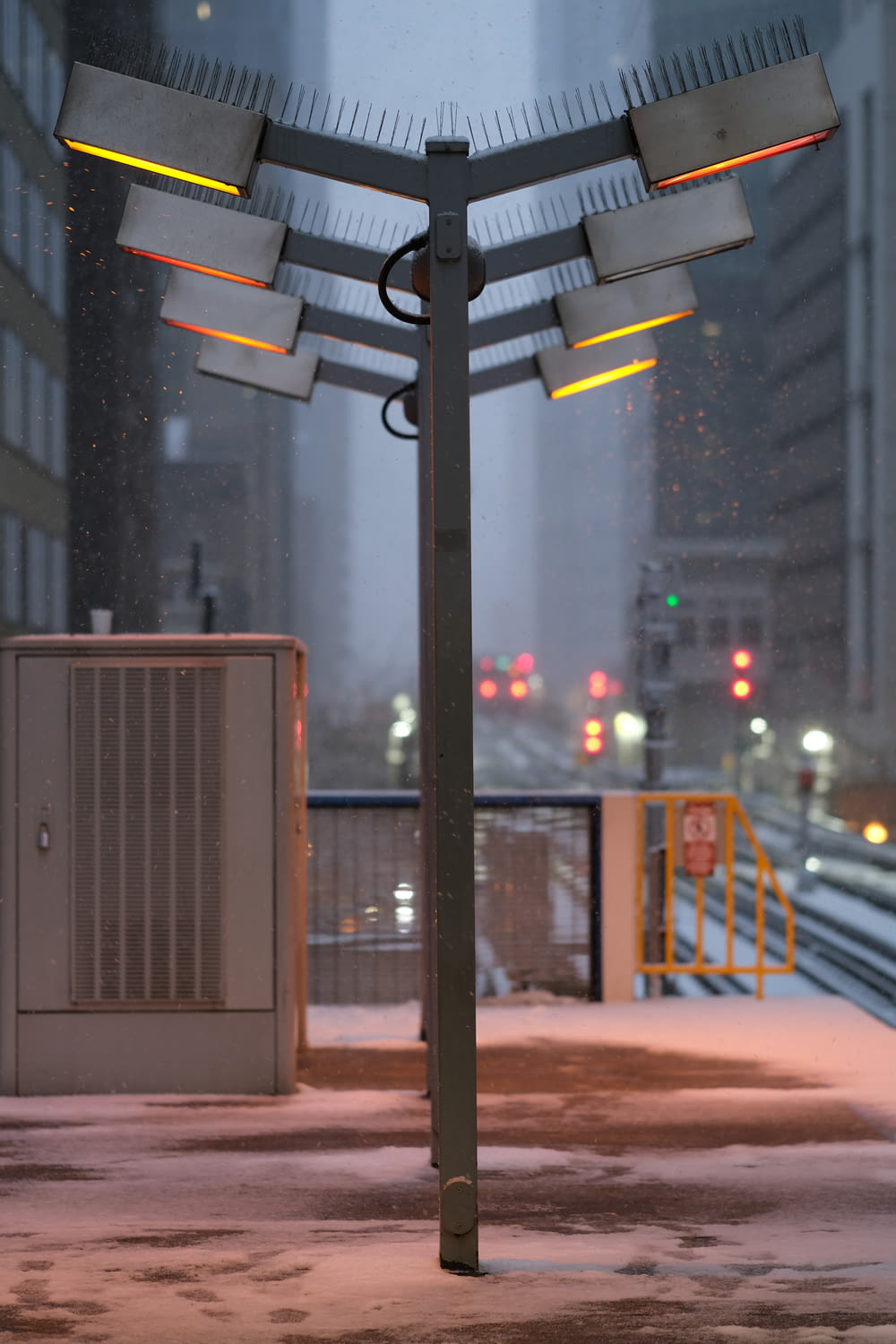 a street light in the middle of a snowy city