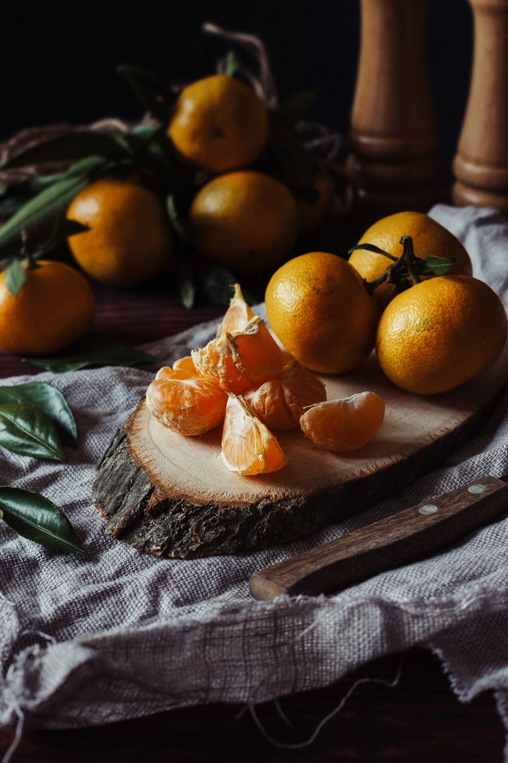 a wooden board topped with oranges on top of a table