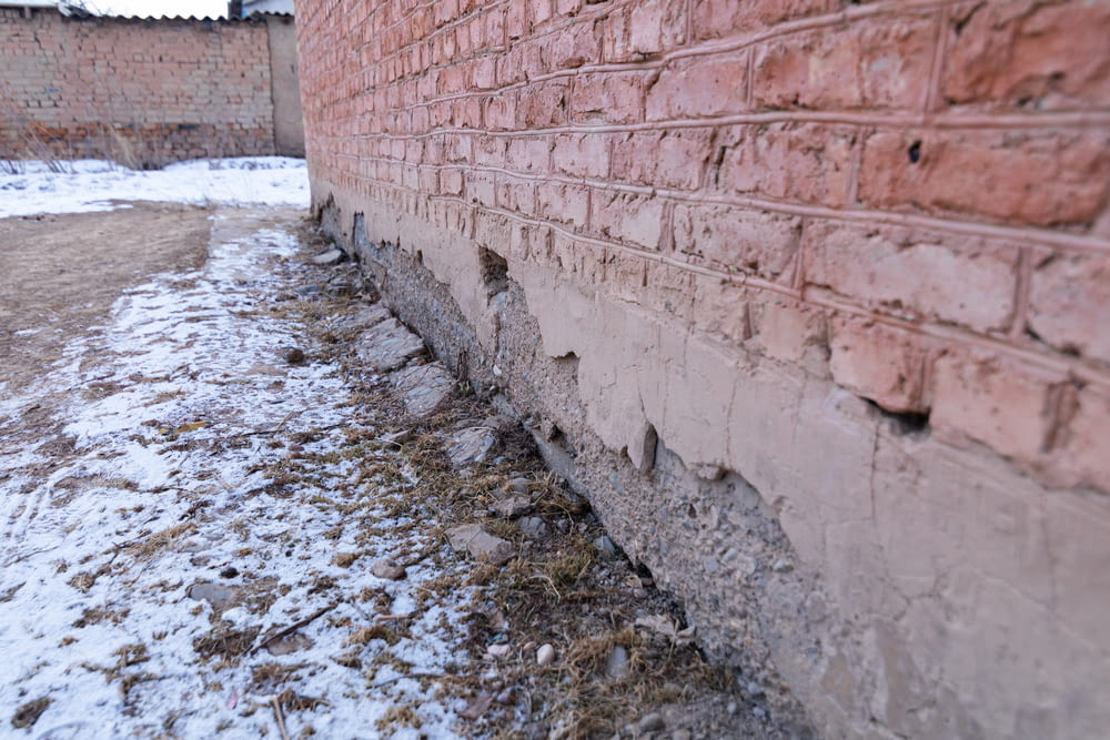a brick wall that has been partially covered in snow