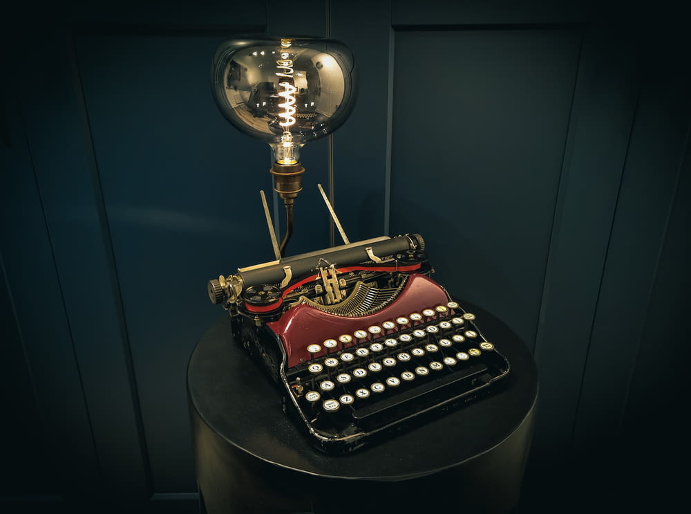 Una máquina de escribir pasada de moda sentada encima de una mesa