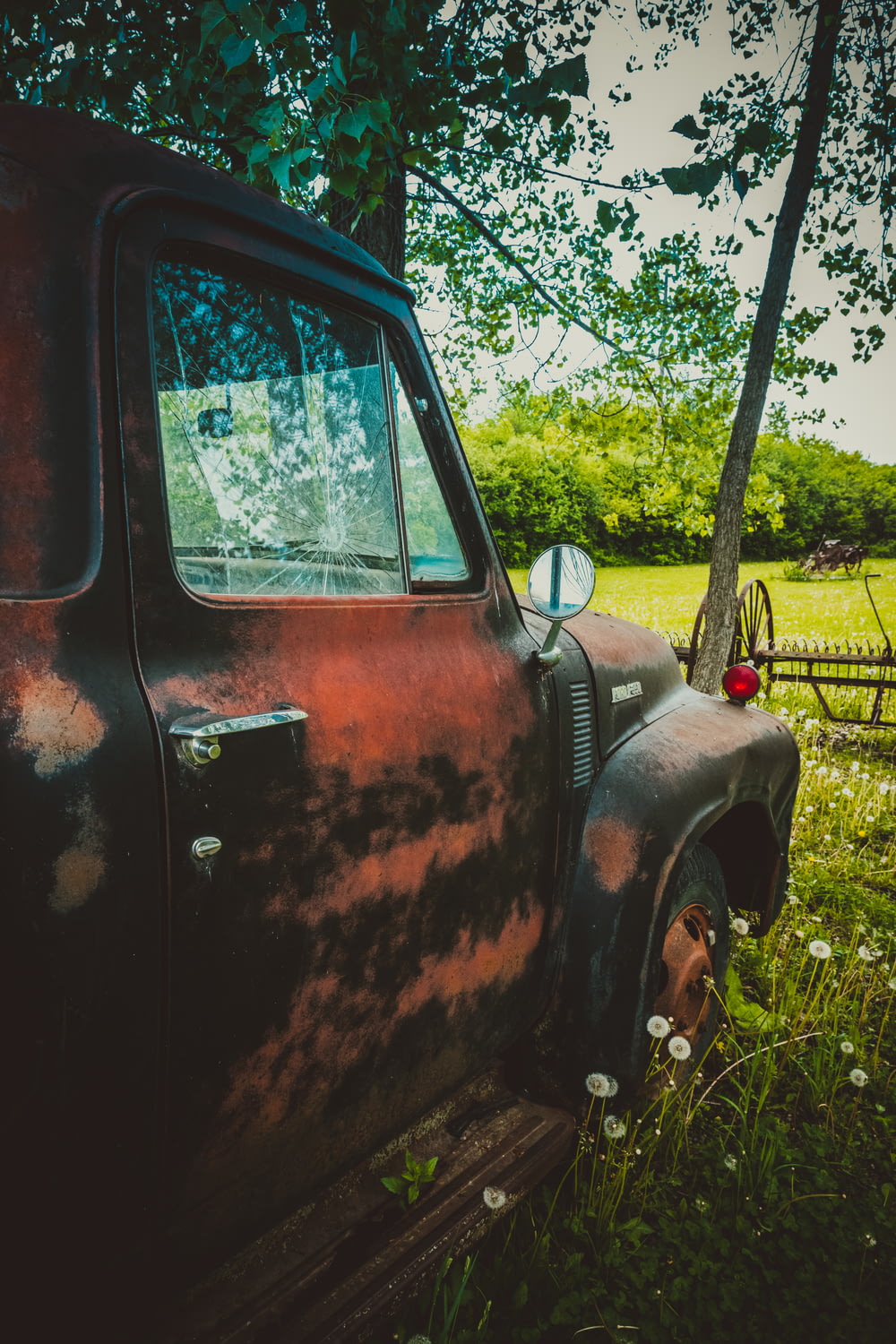 an old truck is parked in a field