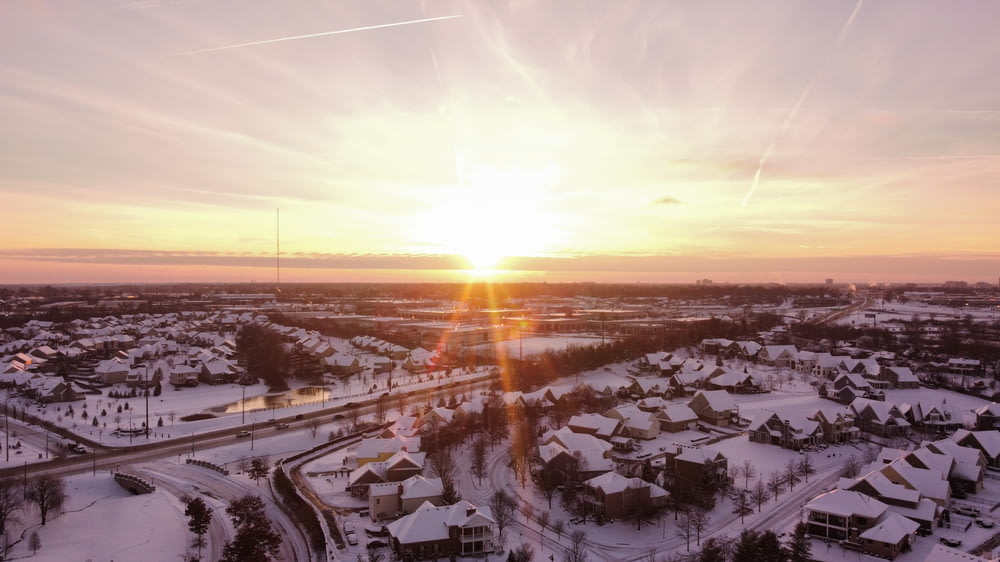 the sun is setting over a snowy town