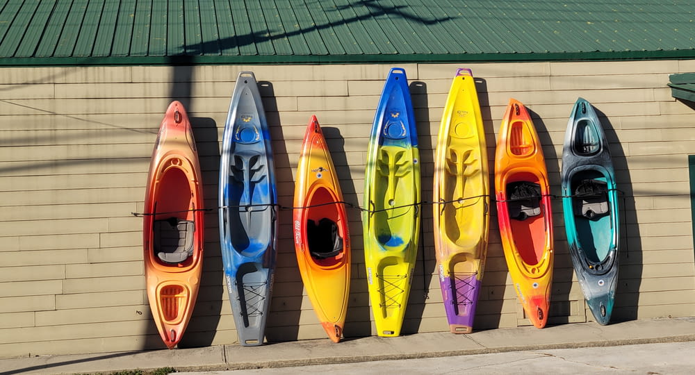 a row of kayaks lined up against a wall