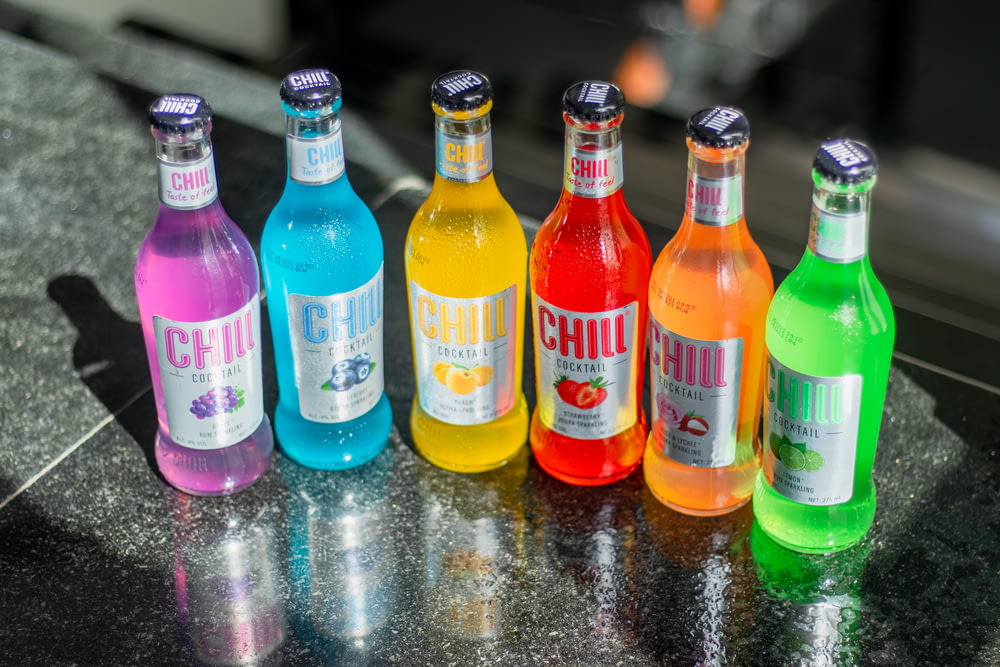 a group of bottles of different colored drinks