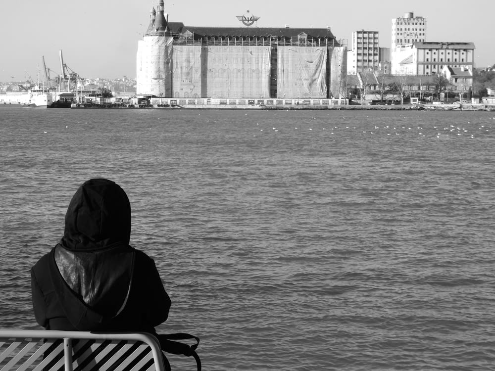 a person sitting on a bench looking out over the water
