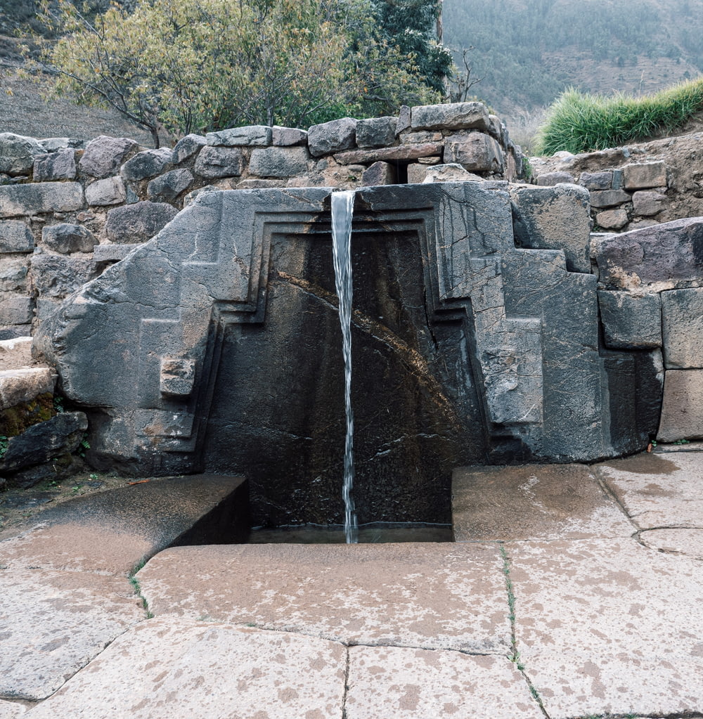 a large stone structure with a waterfall coming out of it