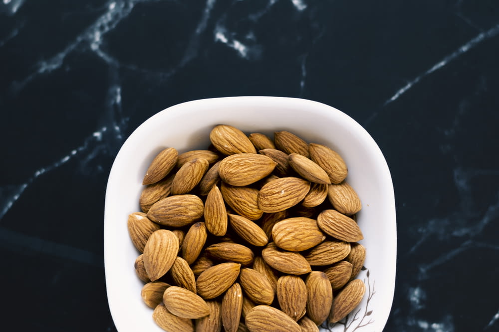 a white bowl filled with almonds on top of a table