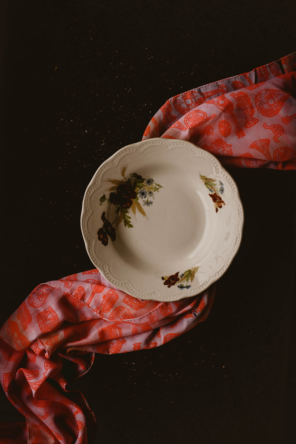 a white plate sitting on top of a red cloth