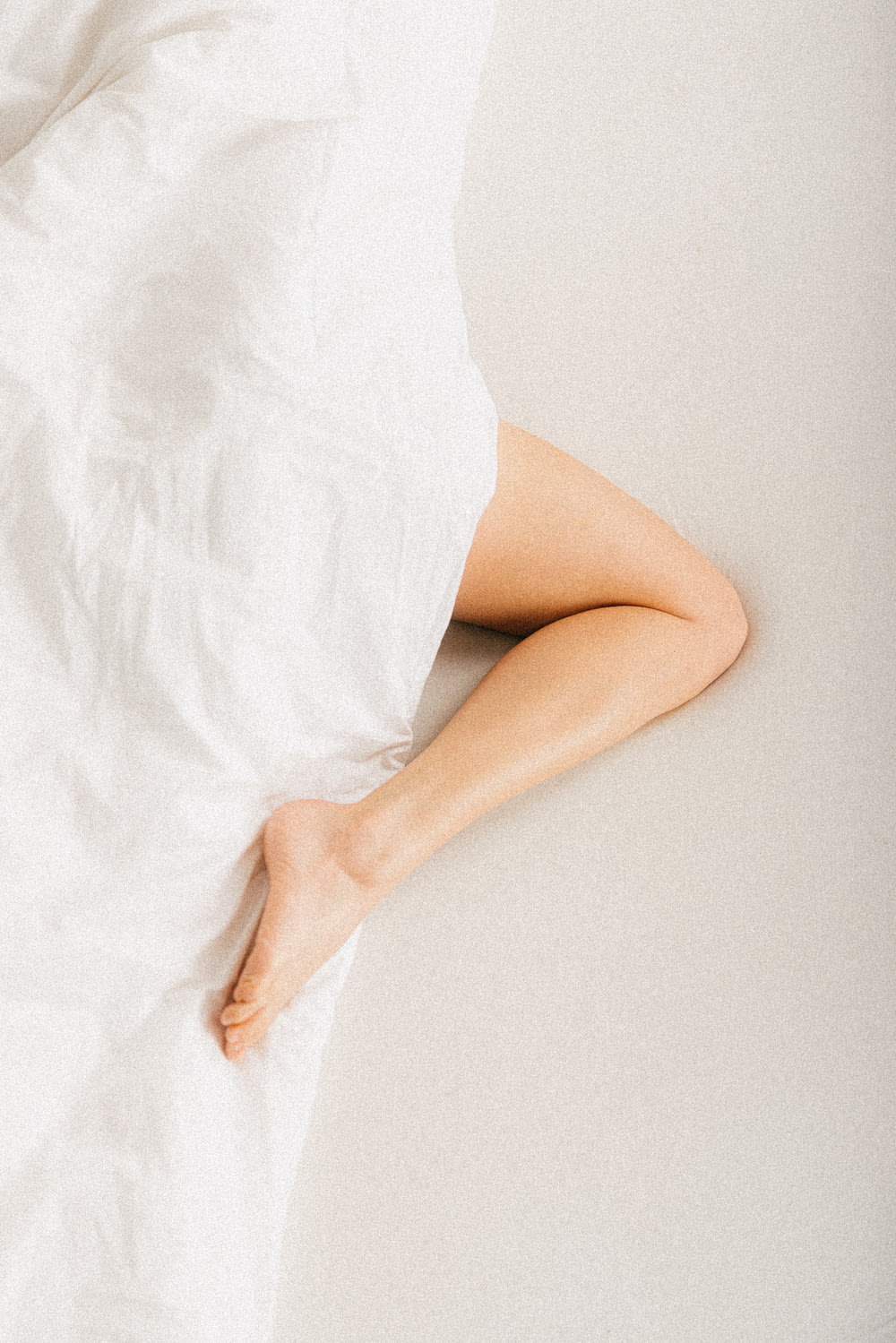 une personne allongée dans un lit avec un drap blanc