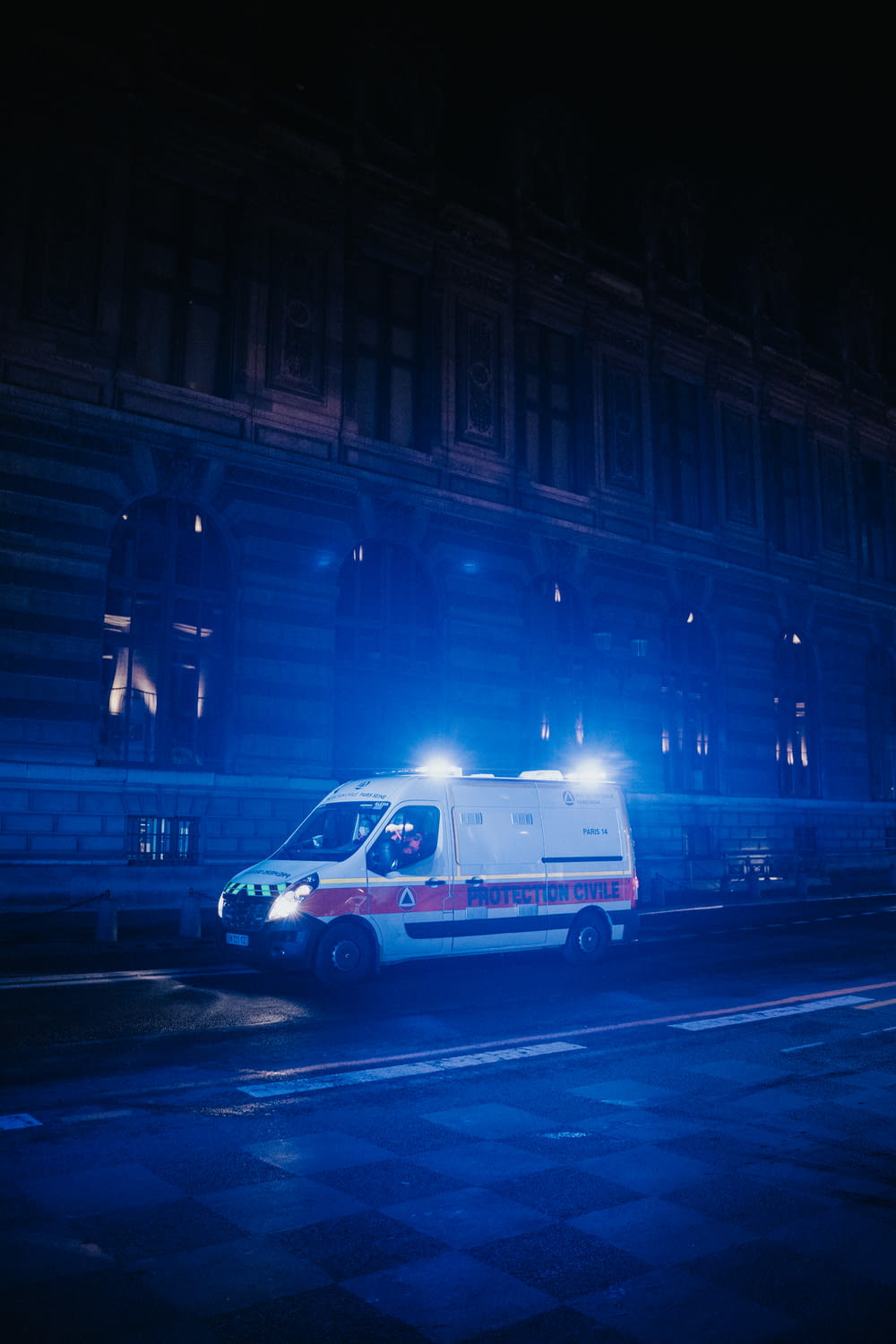 an ambulance parked on the side of the road at night