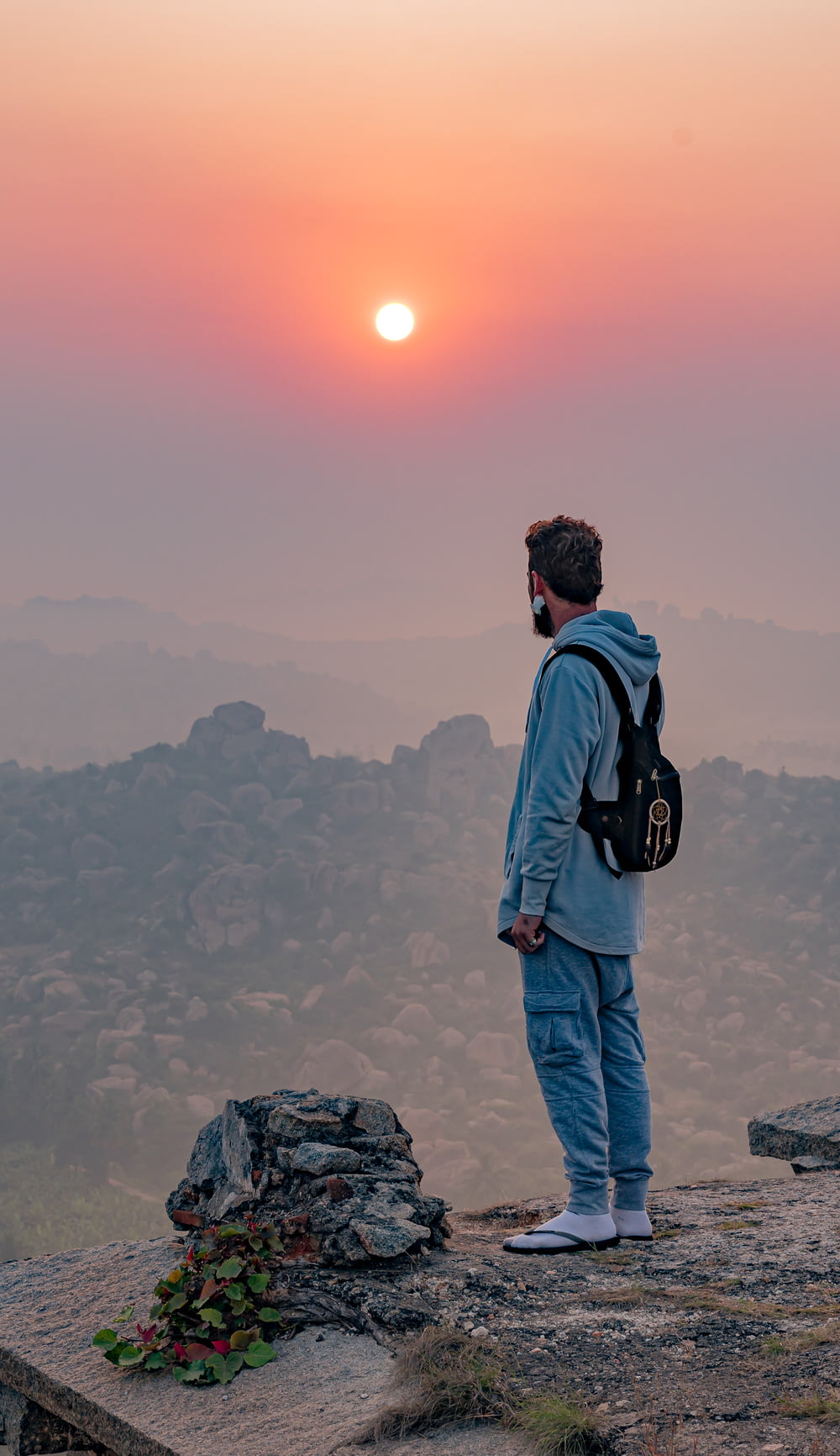 a man standing on top of a mountain with a backpack