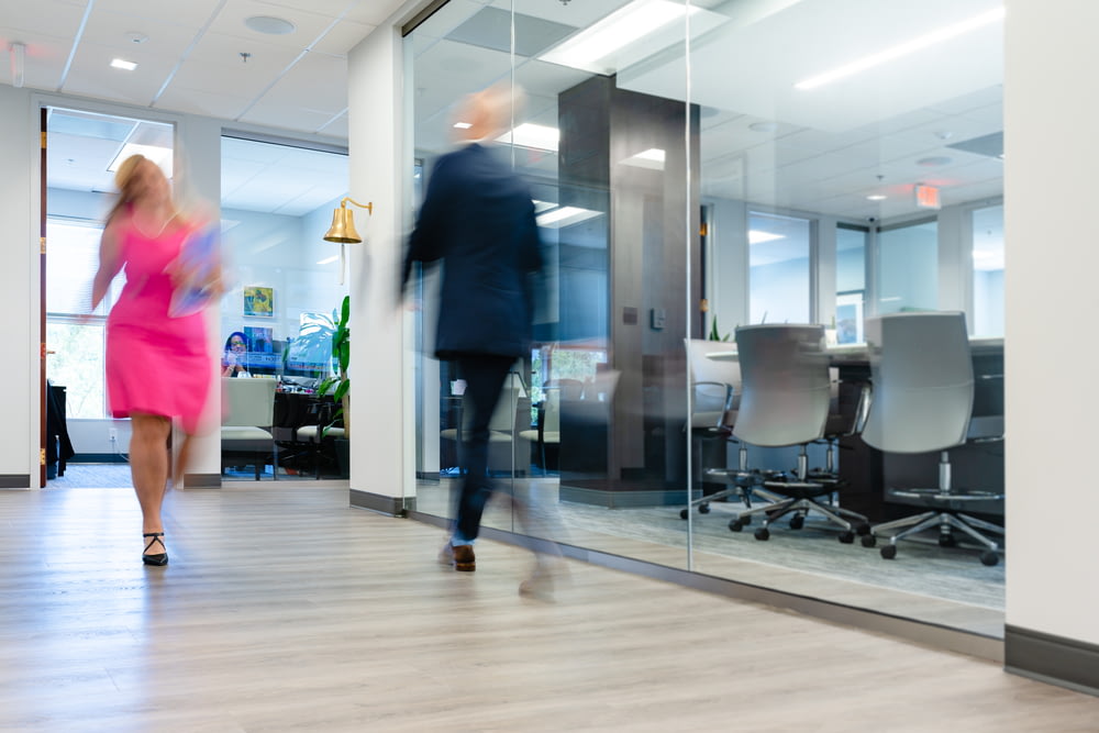 a blurry photo of a man and a woman walking in an office