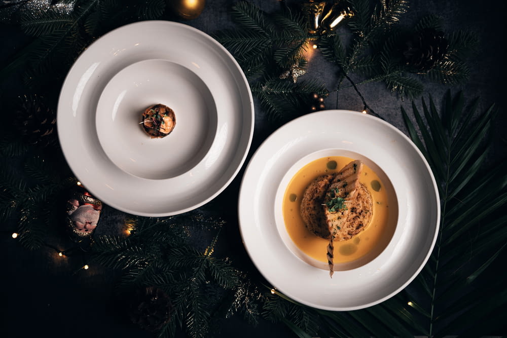 two plates of food on a table next to a christmas tree