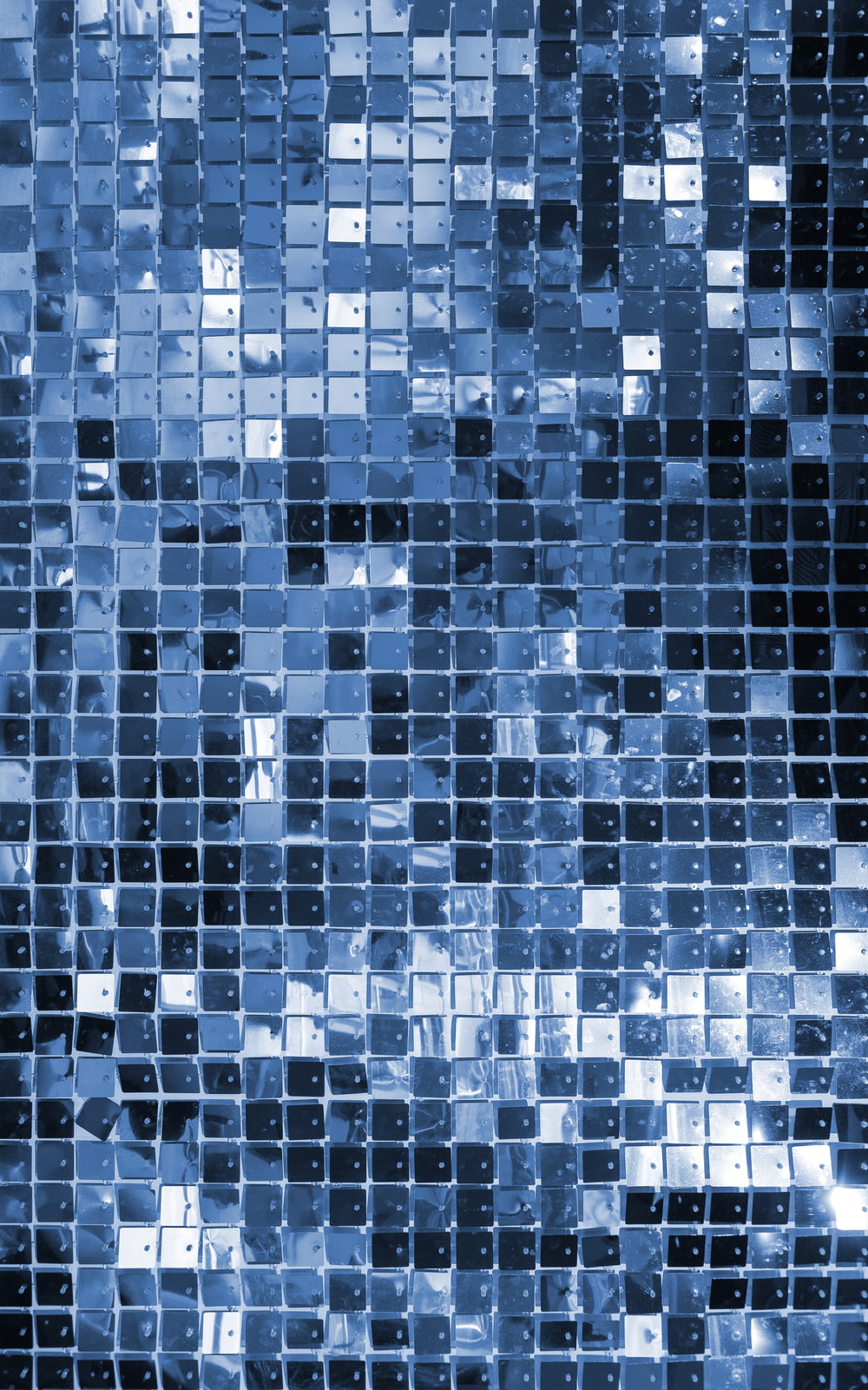 a blue mosaic tile wall with a black background