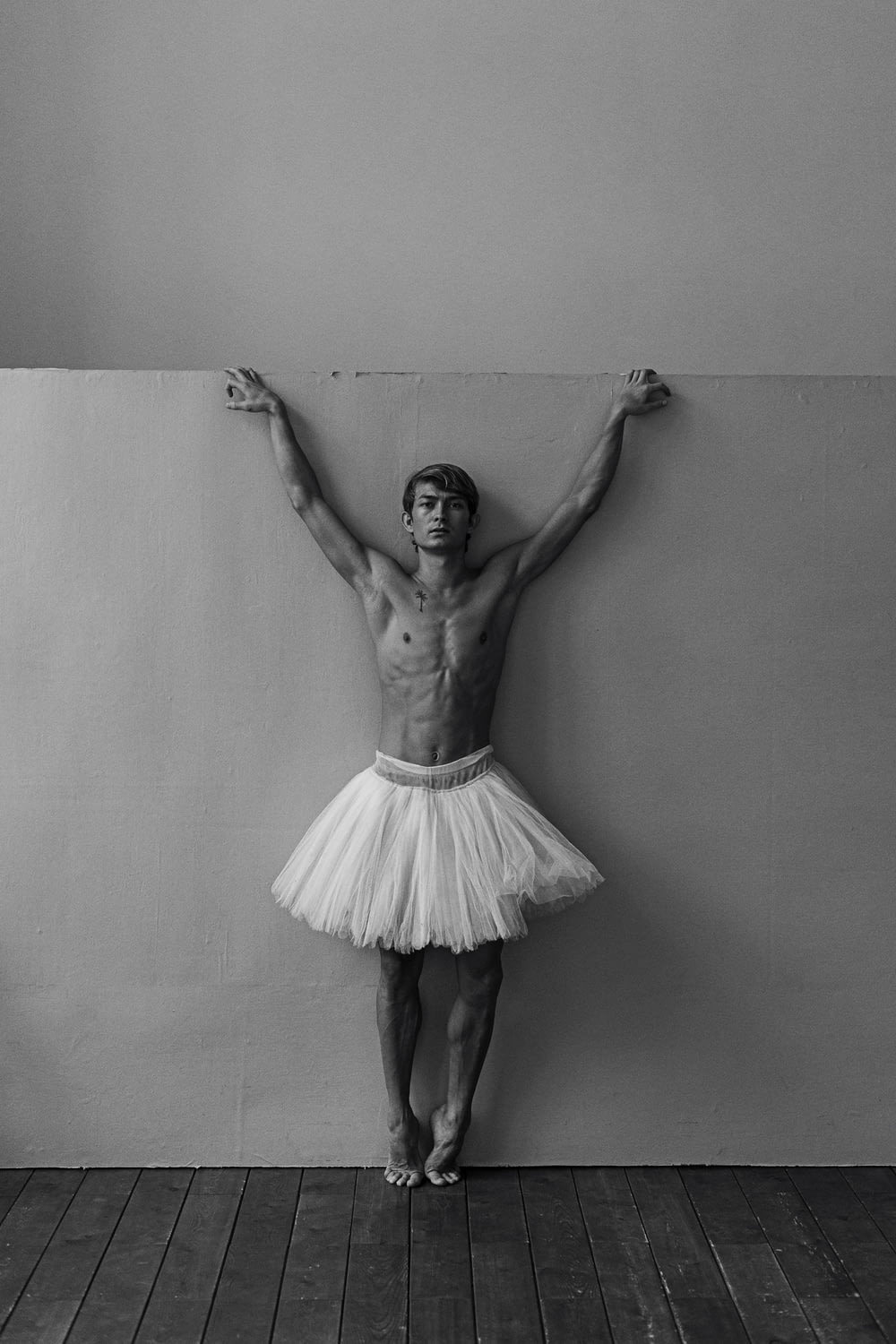 a man in a tutu standing in front of a wall