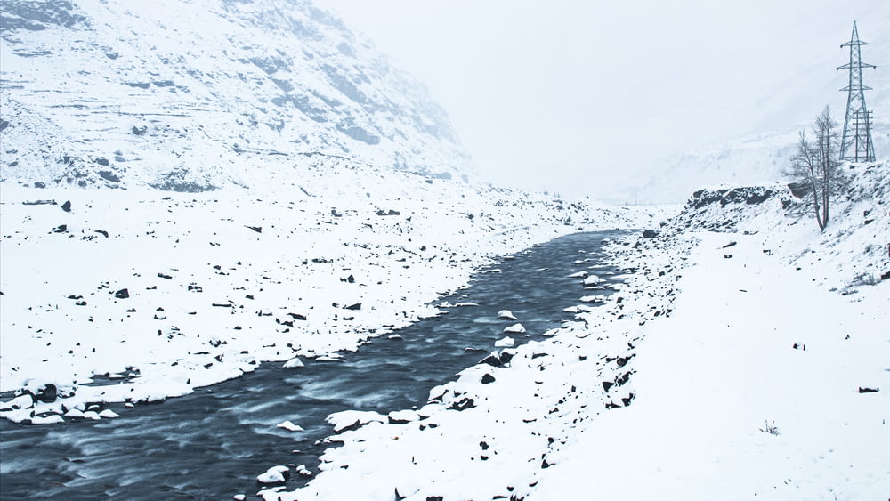 雪に覆われた山腹を流れる川