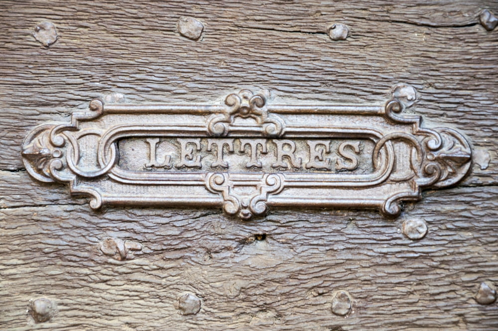 a close up of a metal sign on a wooden surface