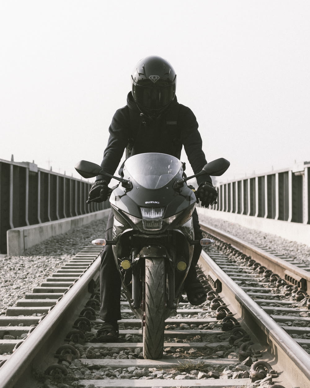 a man riding a motorcycle down a train track