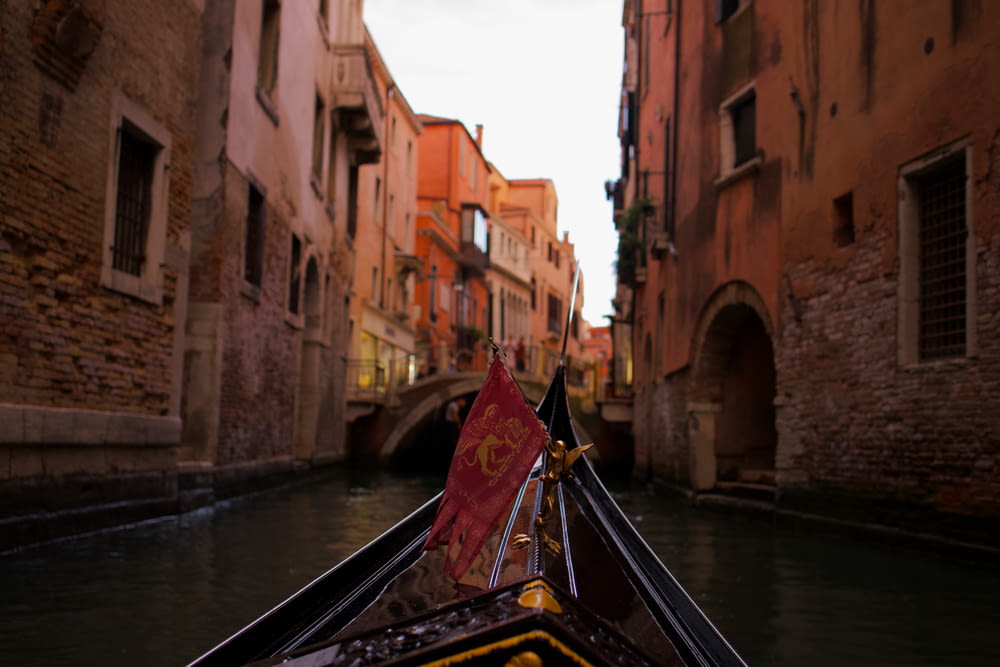 a gondola with a red flag in a narrow canal