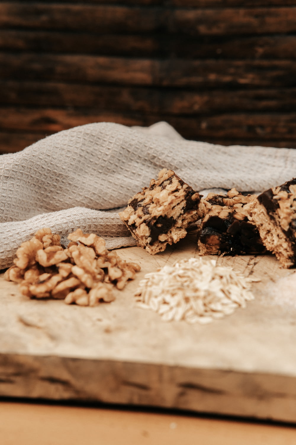 a wooden cutting board topped with granola and chocolate