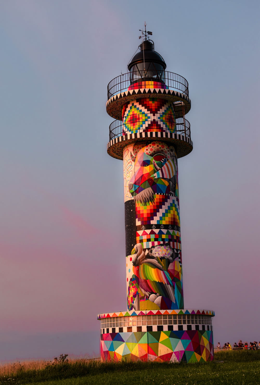 a large multicolored lighthouse on top of a hill