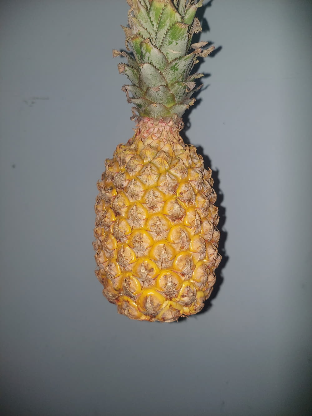a pineapple hanging from the side of a wall
