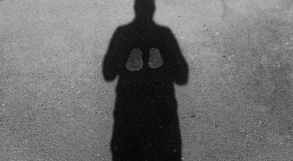 a shadow of a person standing in front of a wall