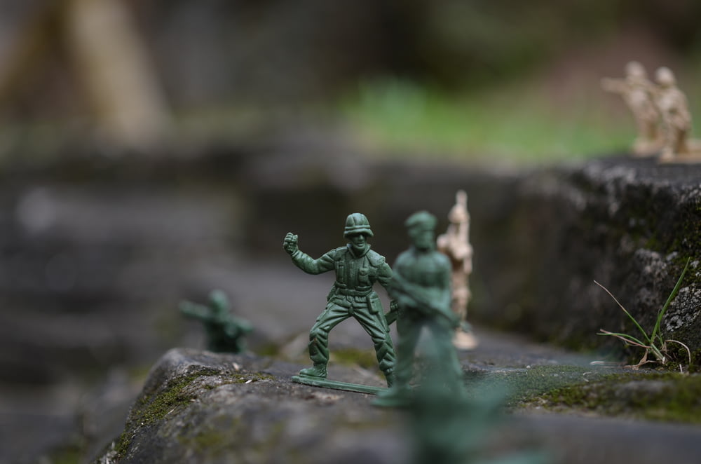 a group of toy soldiers standing on top of a rock