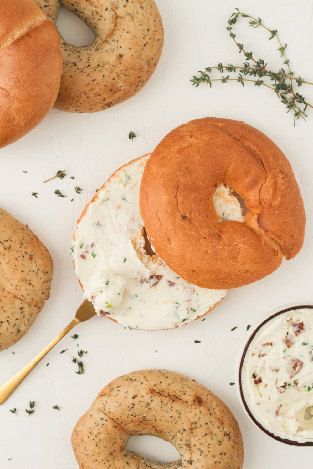 a table topped with bagels covered in cream cheese