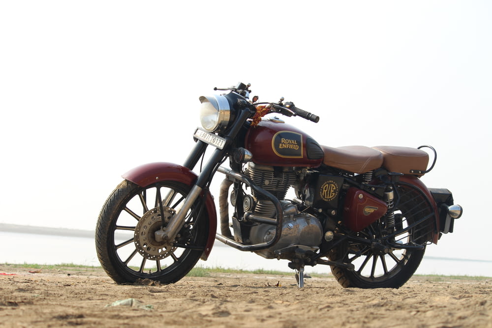 a motorcycle parked on a beach near the ocean