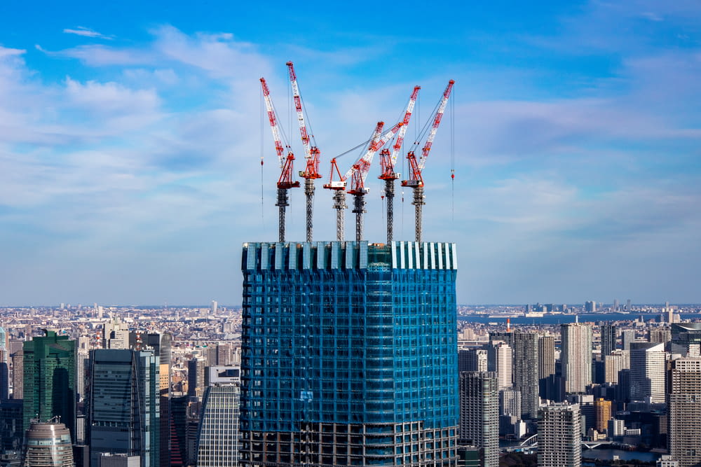 a tall building with cranes on top of it