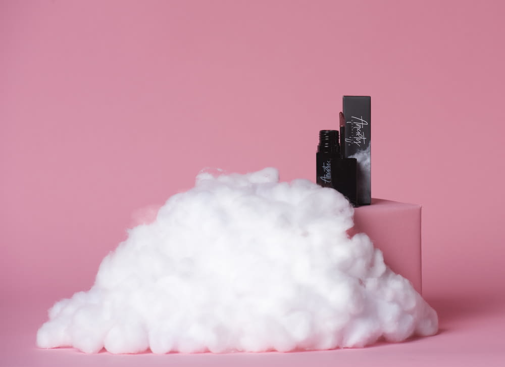 a pile of cotton sitting on top of a pink surface
