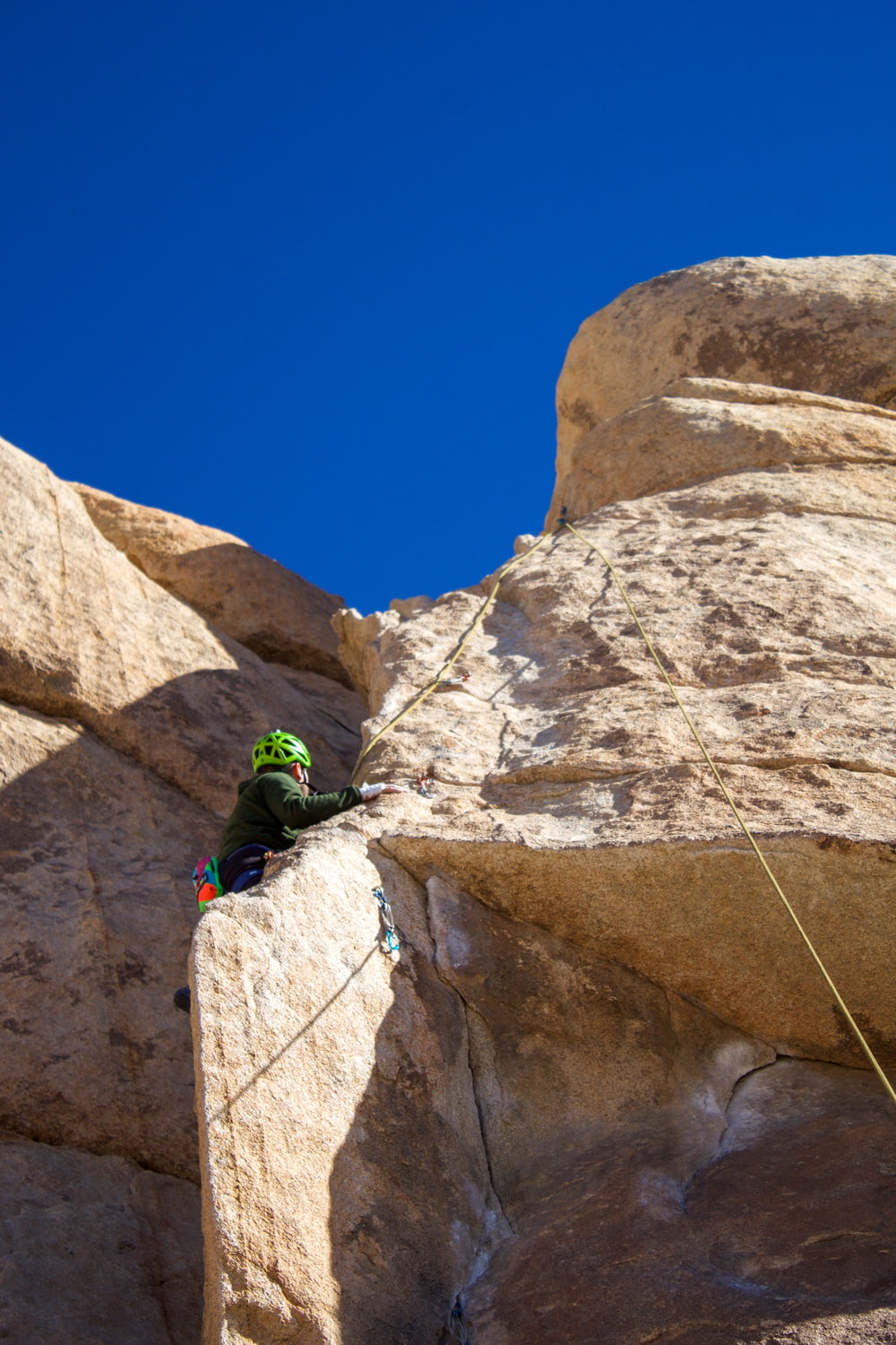 Un uomo che si arrampica sul fianco di una grande roccia
