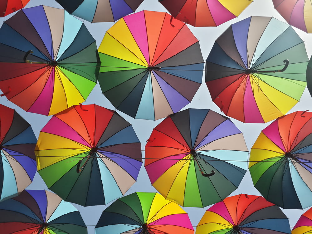 a group of multicolored umbrellas hanging from a ceiling
