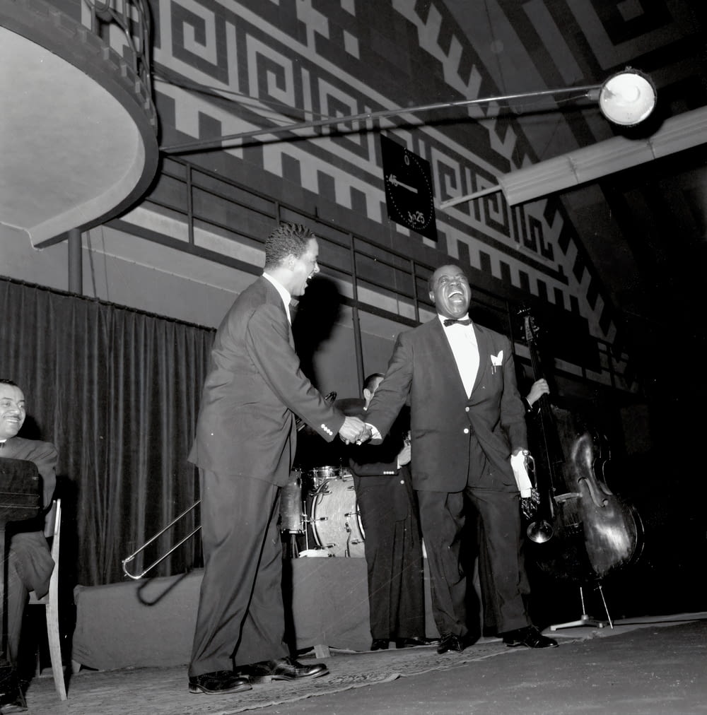 a couple of men shaking hands in front of a microphone