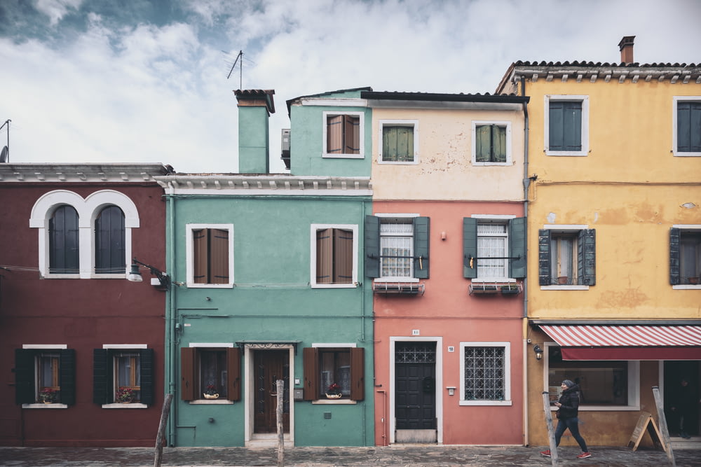 a person walking past a row of colorful buildings