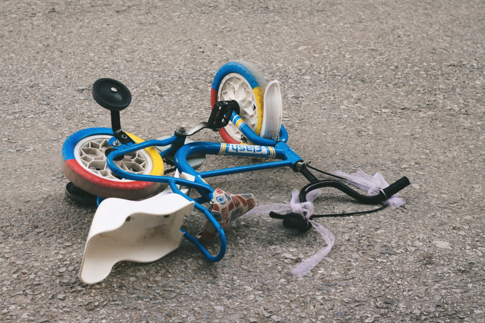 Una bicicletta giocattolo rotta che giace a terra
