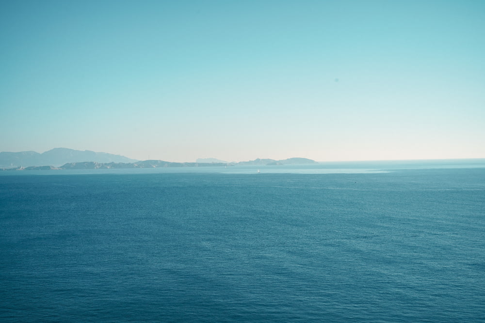 a large body of water with mountains in the distance