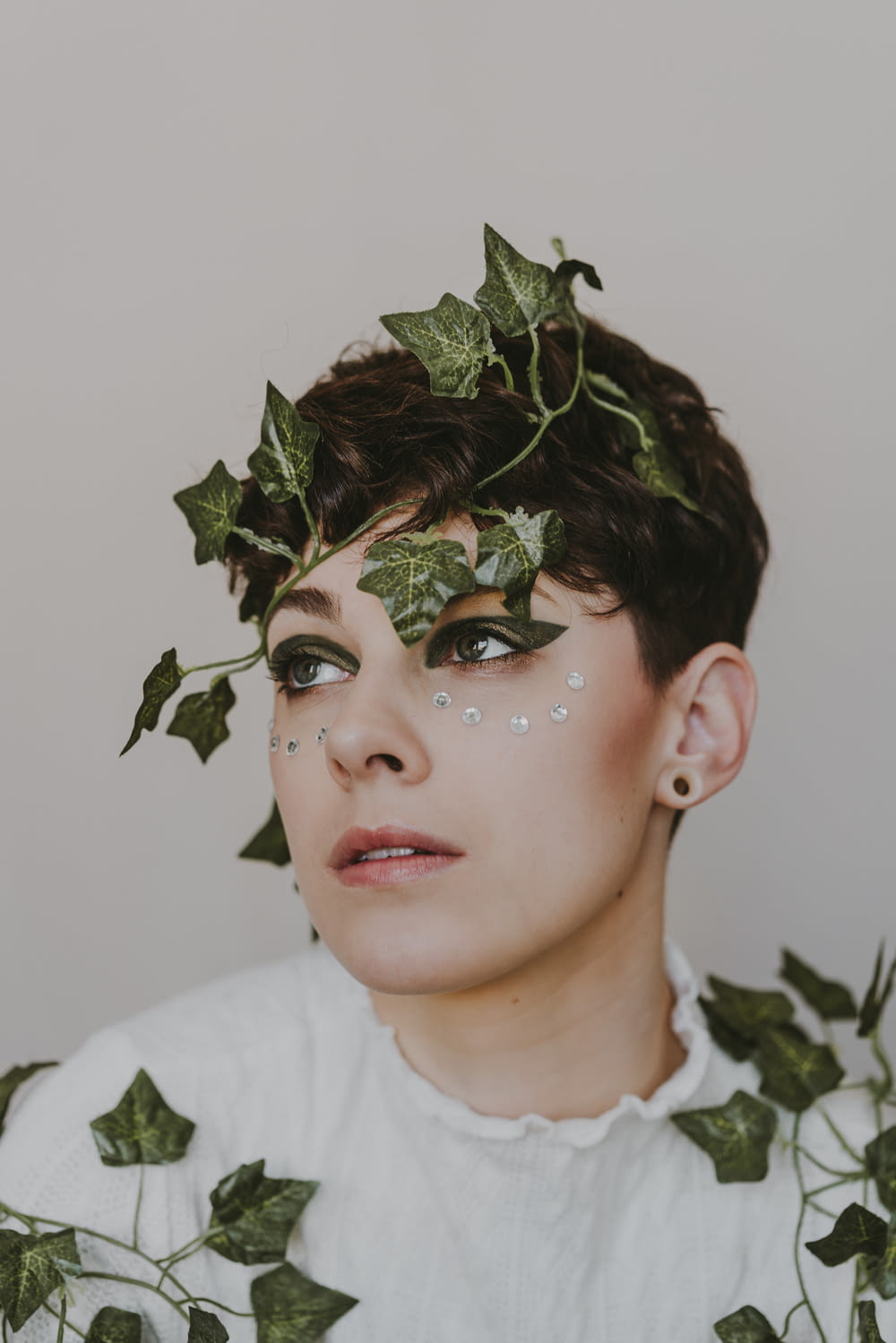 a woman with ivy leaves on her face