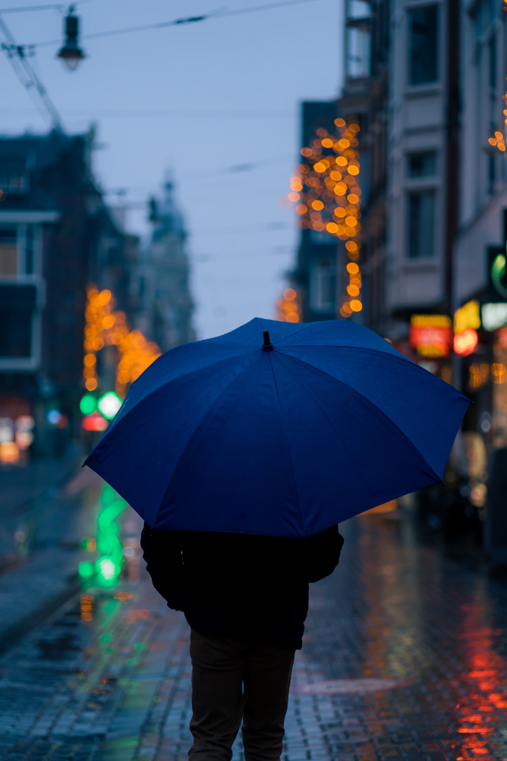 우산을 들고 거리를 걷고 있는 사람