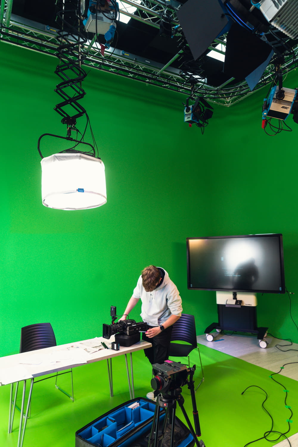 a man sitting at a table in front of a green screen